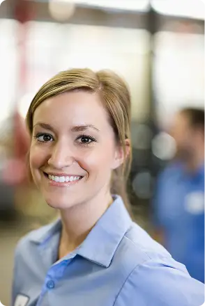A woman wearing a light blue collared shirt smiles at the camera with a blurred background. Traffic Consultants, Inc. (TCI)